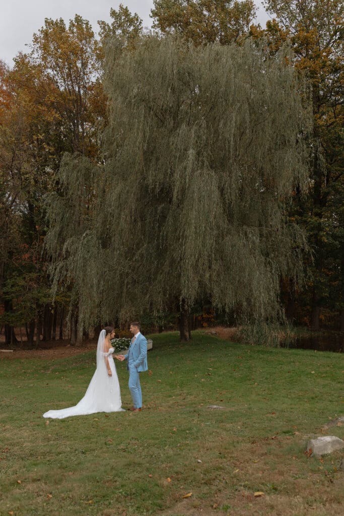 A soon to married couple after their first look sharing a moment by the pond at their venue