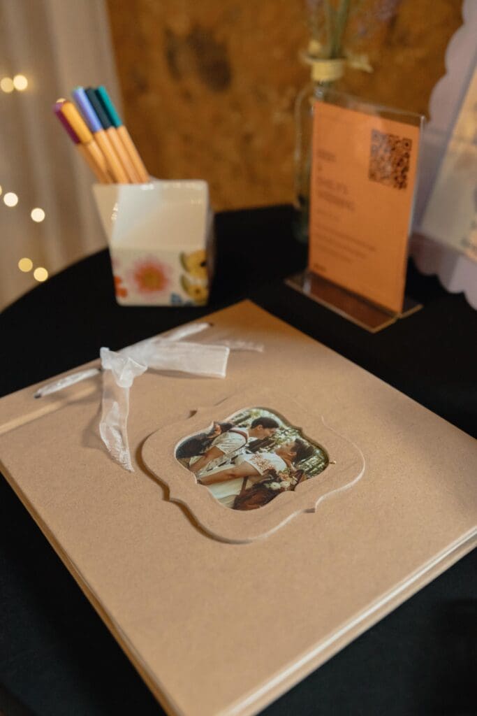 A wedding guest book that is light brown and has a photo of the couples in the center